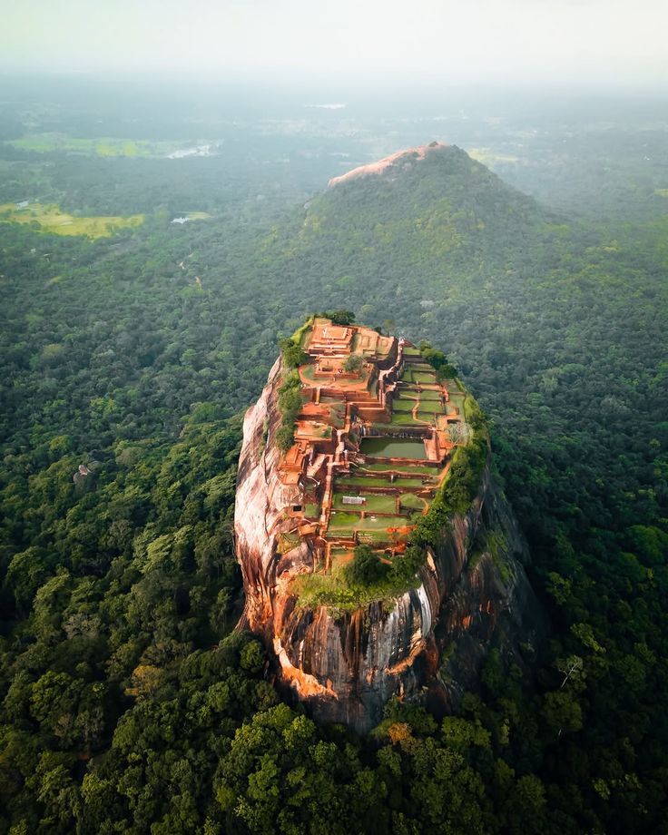 Ancient Sigiriya Rock Fortress surrounded by jungle in Sri Lanka at sunrise